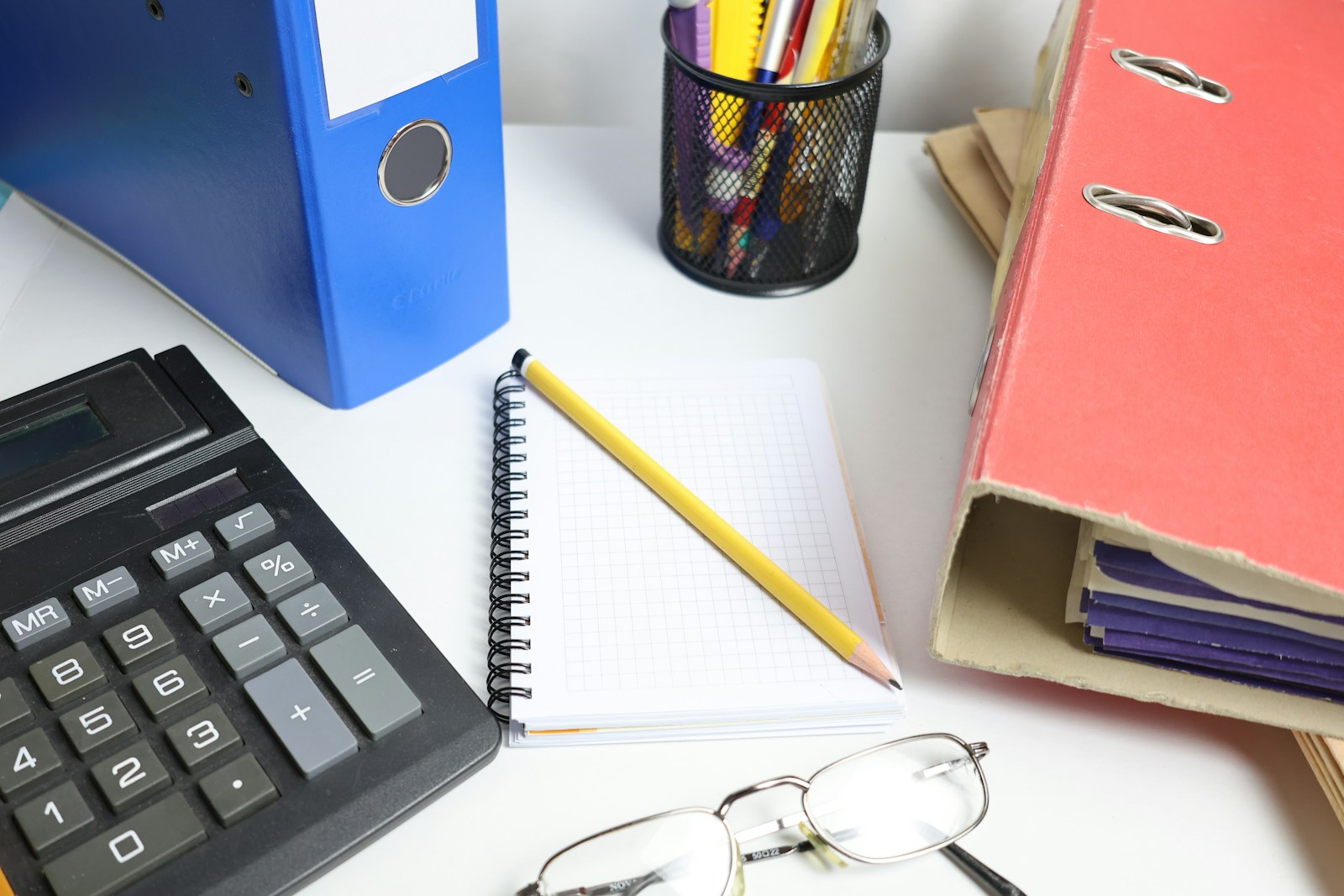Calculator, notebook, pencil and files on an accountant's desk